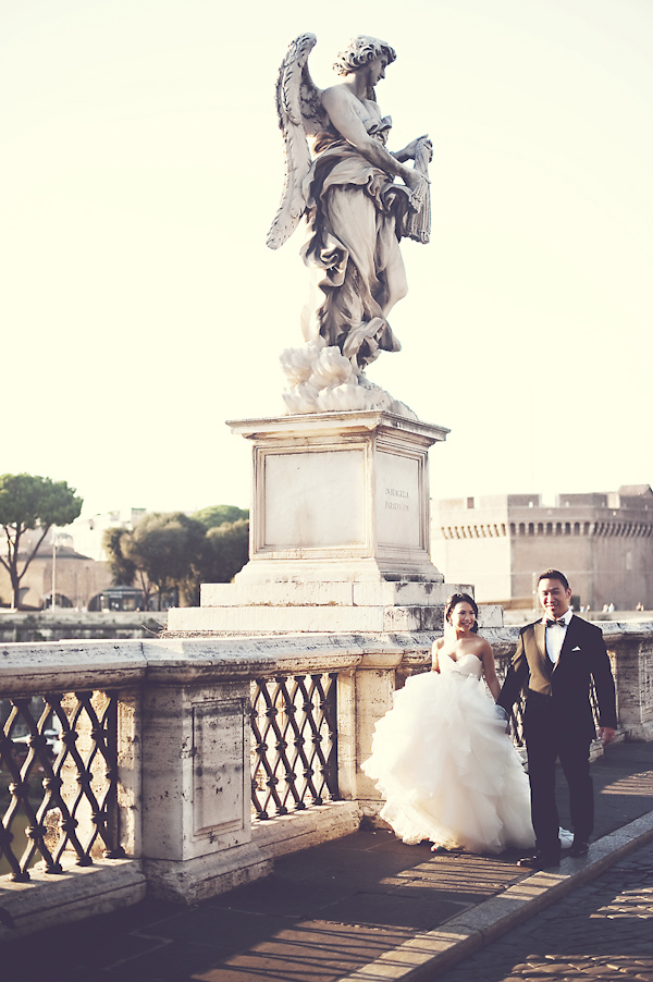 the happy couple walking hand in hand down waterfront - wedding photo by top Rome based destination wedding photographer Rochelle Cheever, Rome Weddings Photography